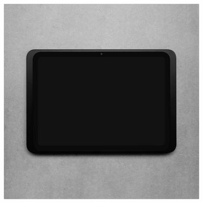 A tablet with a black screen lies flat on a grey concrete background.