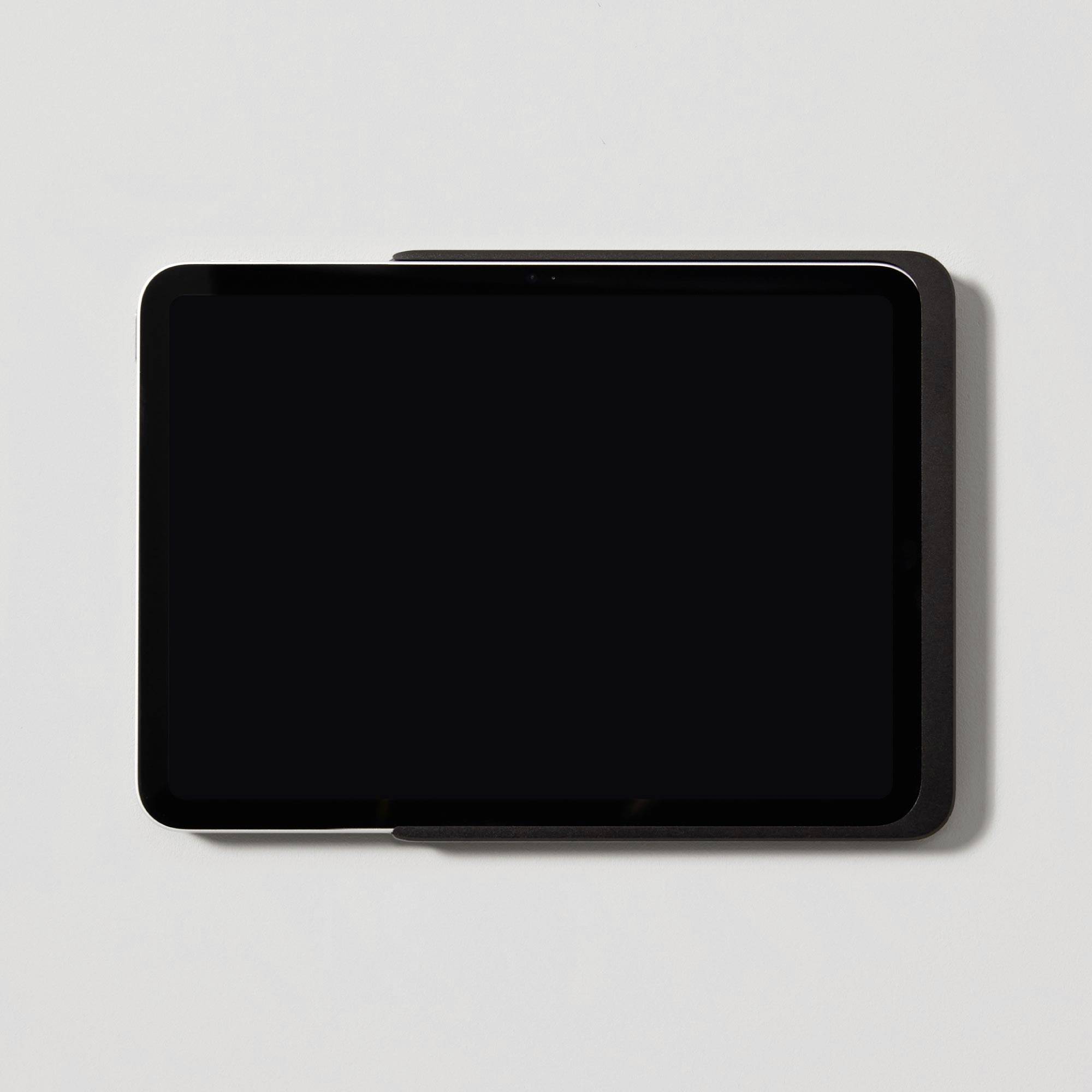 Tablet with a black screen on a grey background, positioned diagonally.