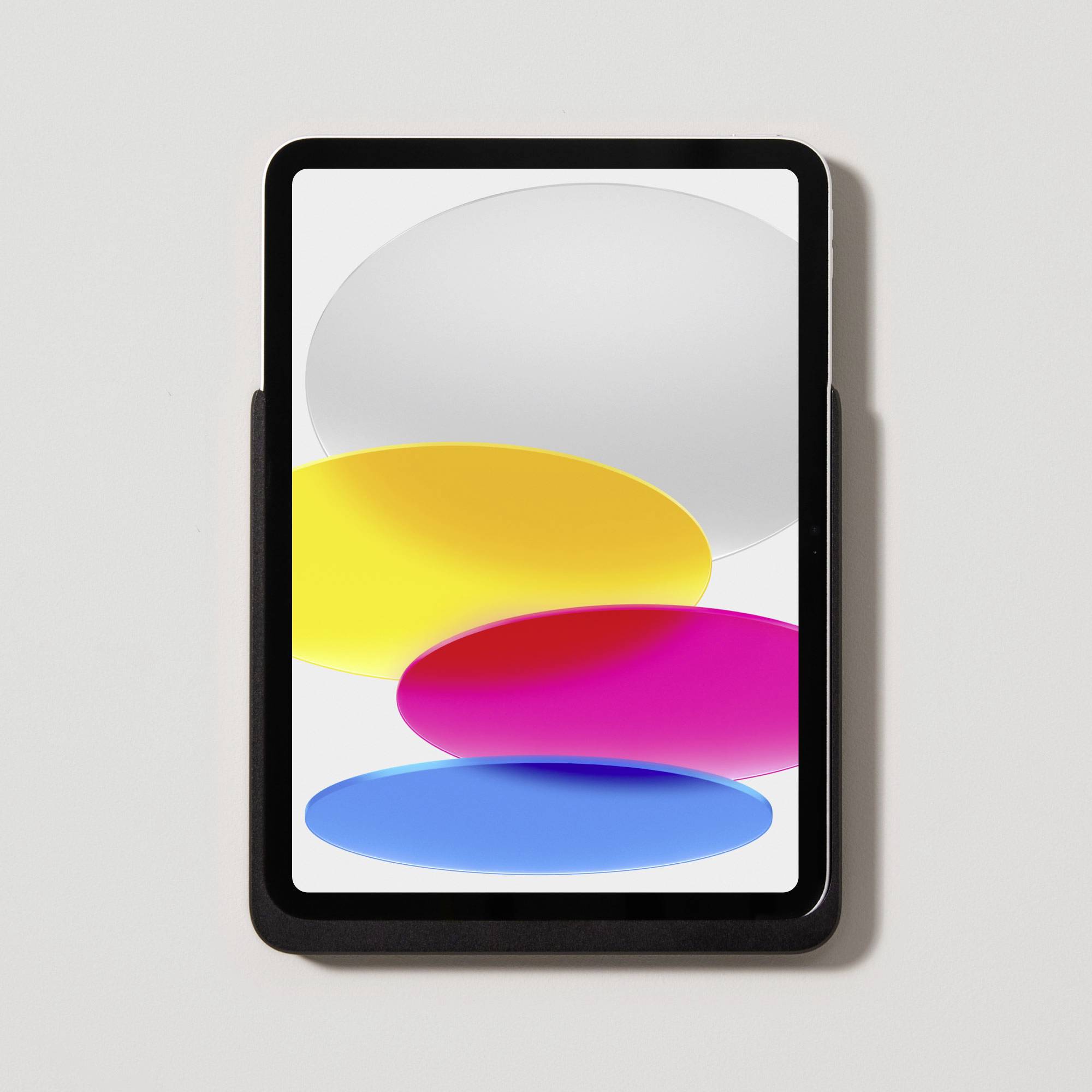 A tablet with oval bubbles in white, yellow, pink, and blue on the screen, showing a colourful and modern display design.