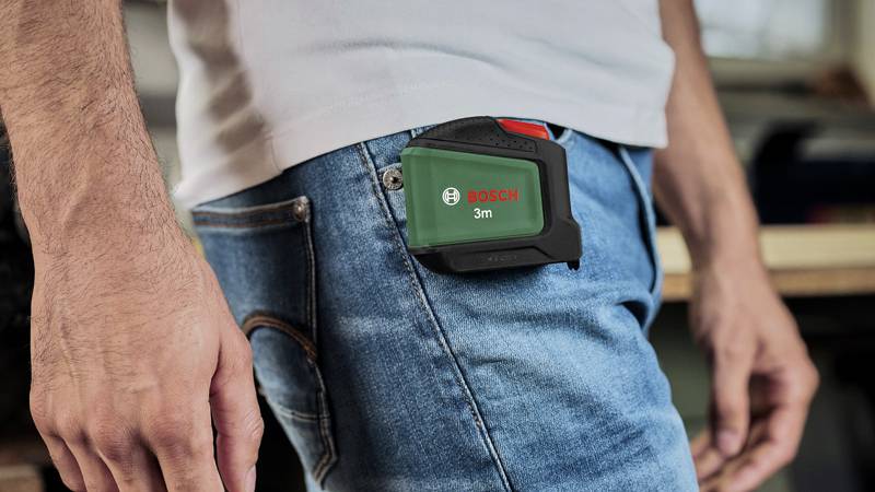 A person with a Bosch laser measuring device in their trouser pocket.