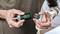 A person is holding a green Bosch screwdriver with a removable capsule handle that contains various bits.