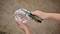 A hand is holding pliers and cutting a white cable being held by another hand.