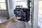 A hand holds a Bosch professional device for levelling building structures on a metal frame in a building under construction.
