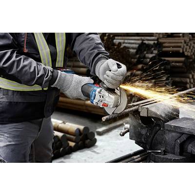 A person is cutting a metal rod with an angle grinder, sparks flying. They are wearing work gloves and protective clothing.
