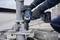 A person is using an electric drill driver to secure metal components of a construction.