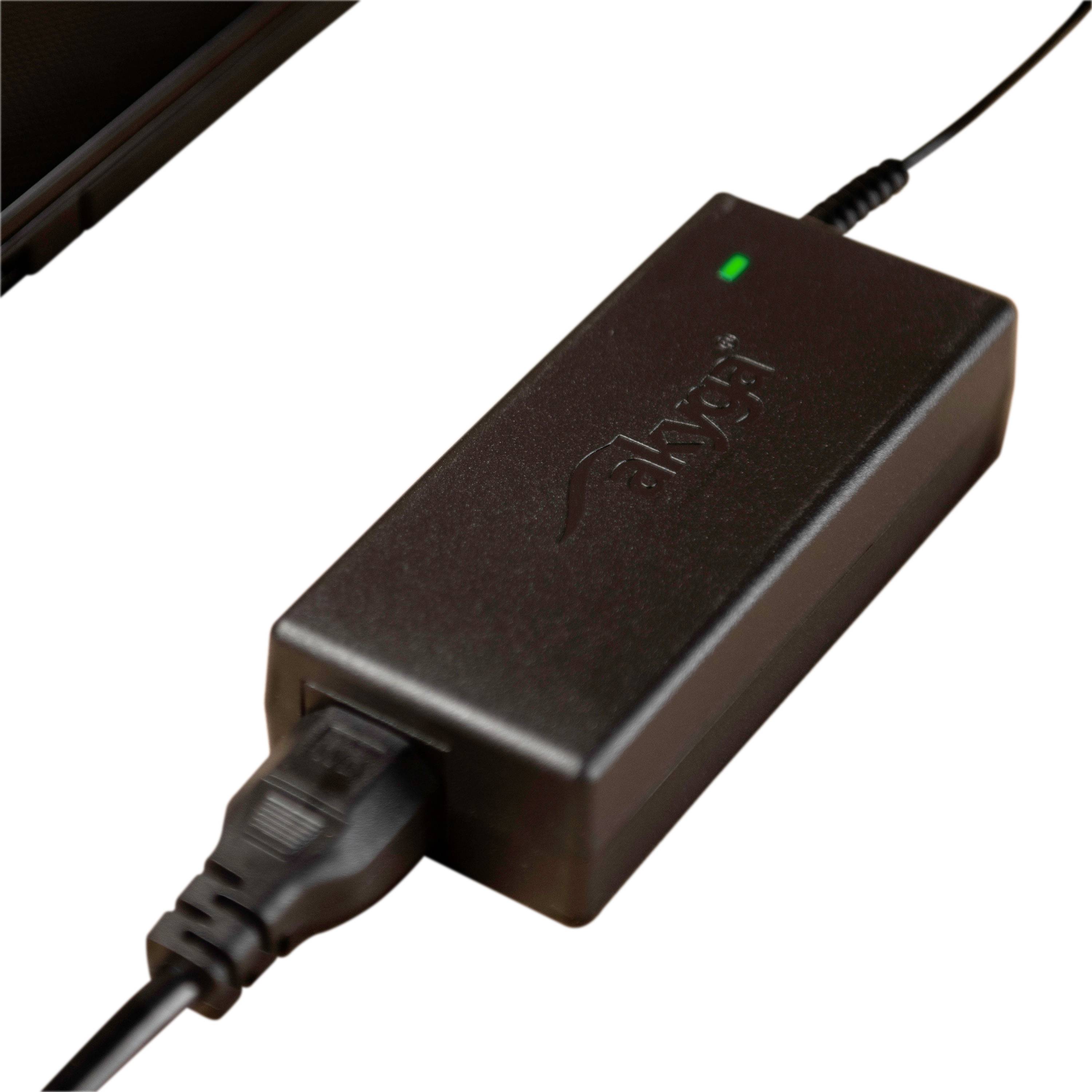 A black power supply with a connected cable shows a glowing green LED indicator.