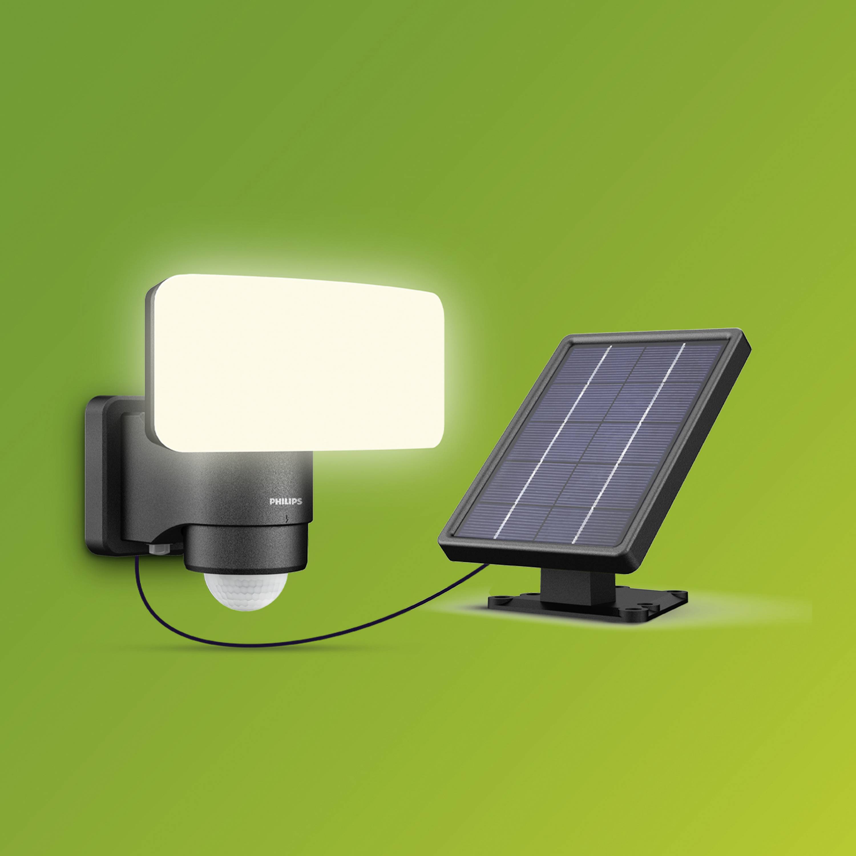 Solar-powered outdoor light with integrated motion sensor, positioned on the left of the image. A solar panel is situated next to it on the right. Green background.