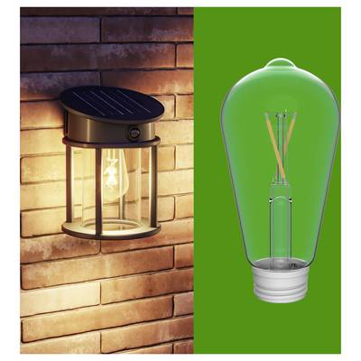 Split image showing a wall-mounted solar lantern lit on a brick wall and a green-tinted LED bulb on a solid green background.