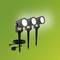 Three black outdoor spotlights with ground stakes, on a green background. They are connected by cables and illuminate forward.