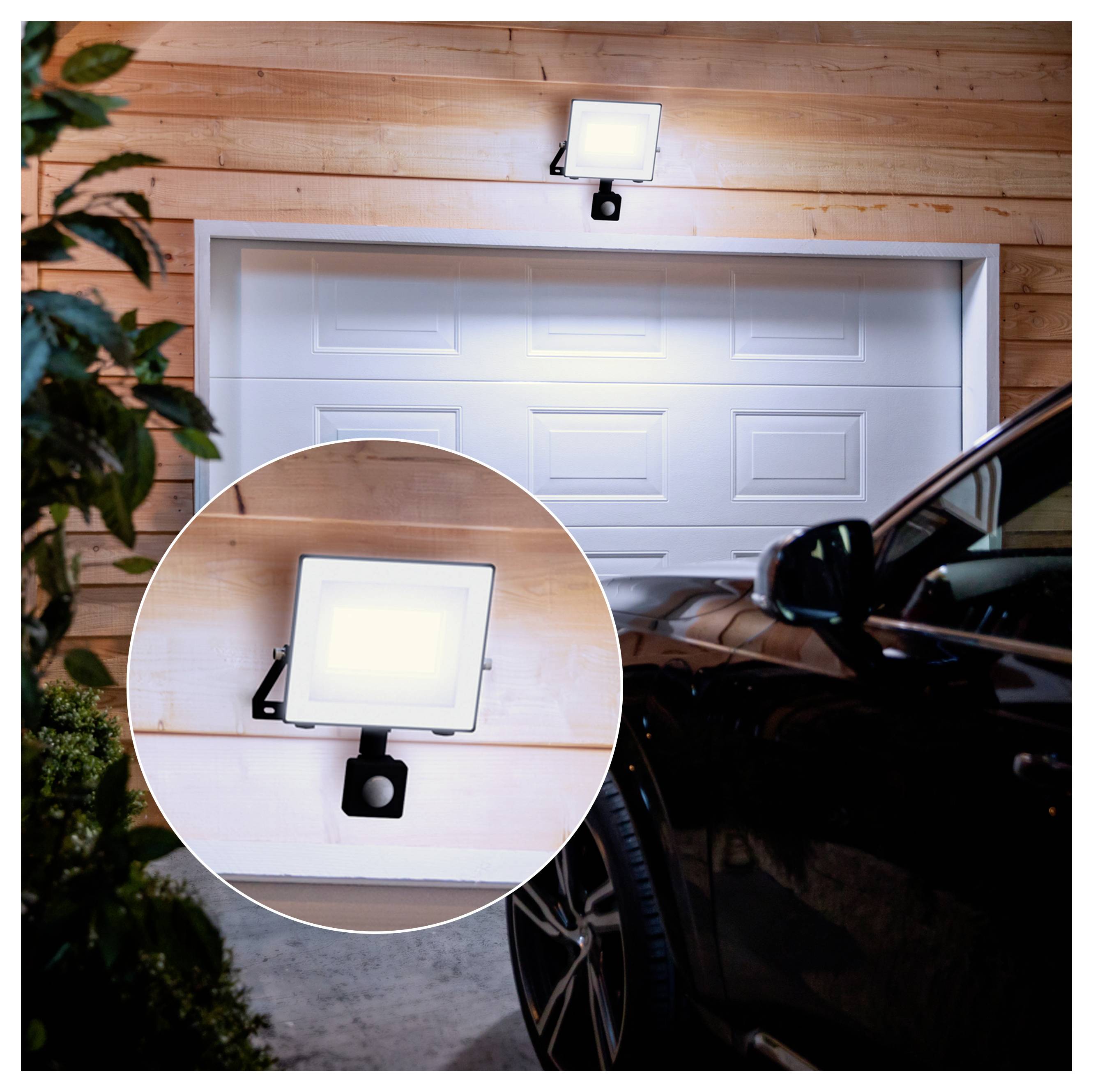 Outdoor garage with a motion-activated floodlight above a closed garage door, shown with a circular inset close-up of the light.