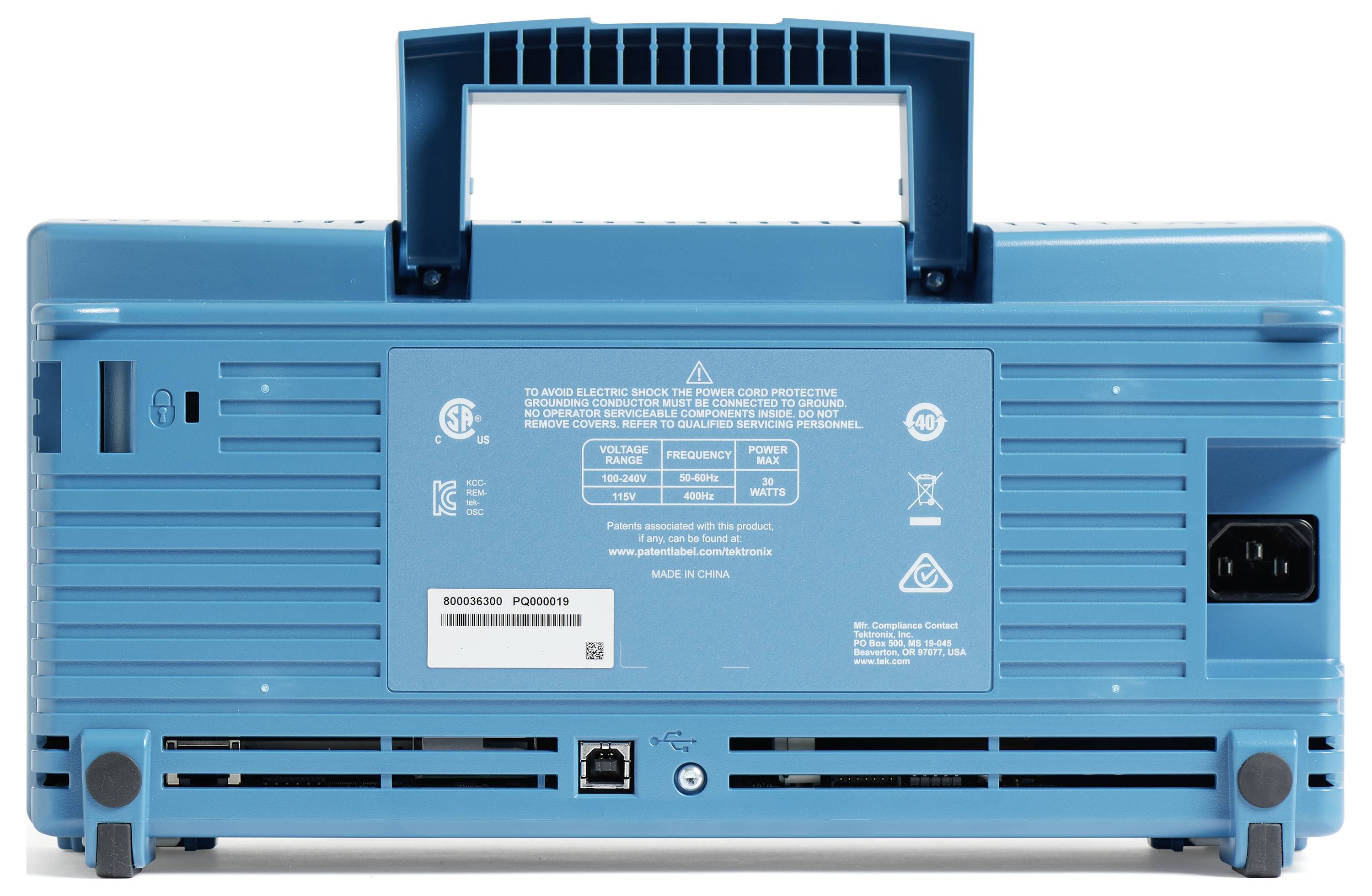 Back of a blue portable device with a handle and ventilation slots, showing a label with specifications and safety information.