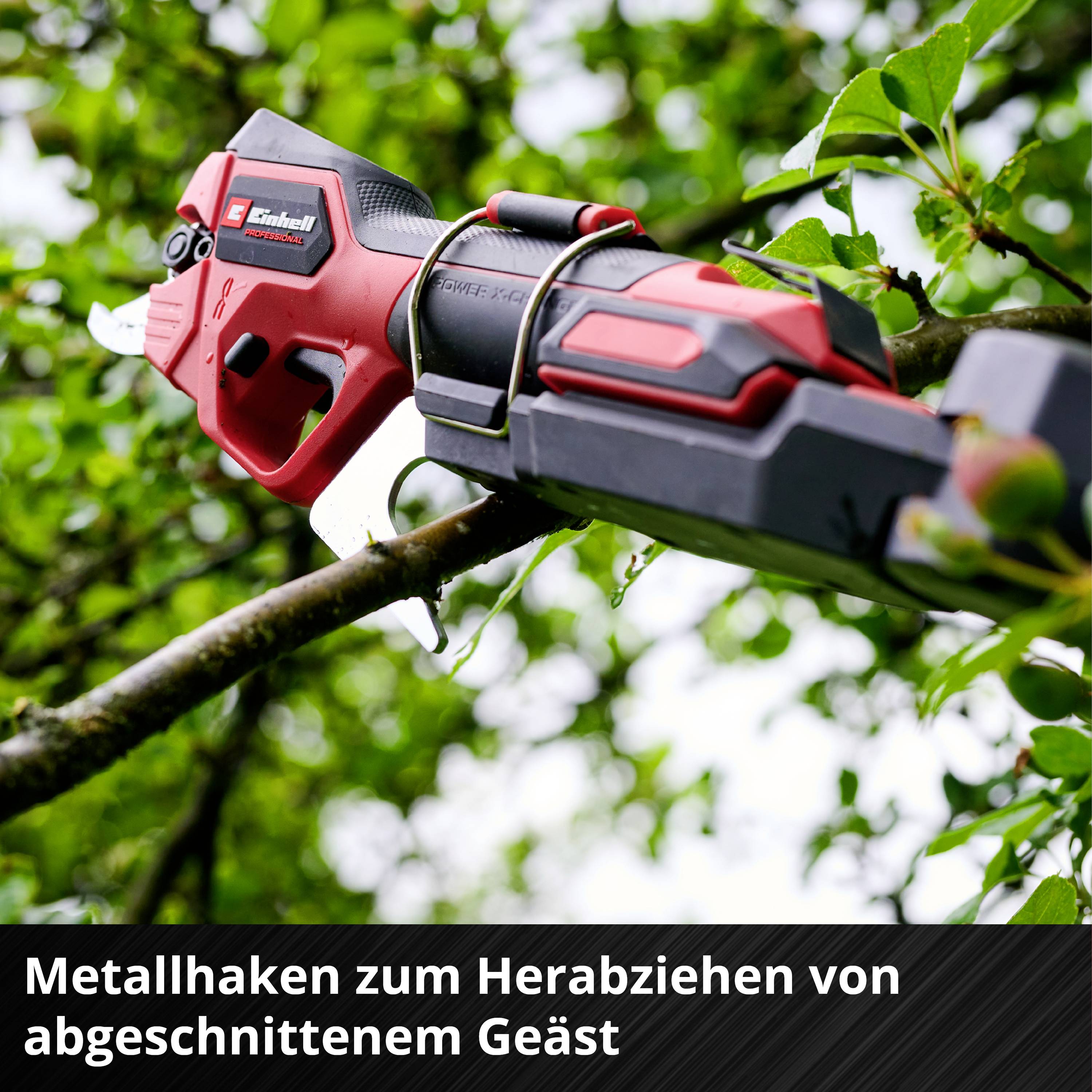 A red, cordless branch pruner cuts a tree branch. The background shows green leaves.