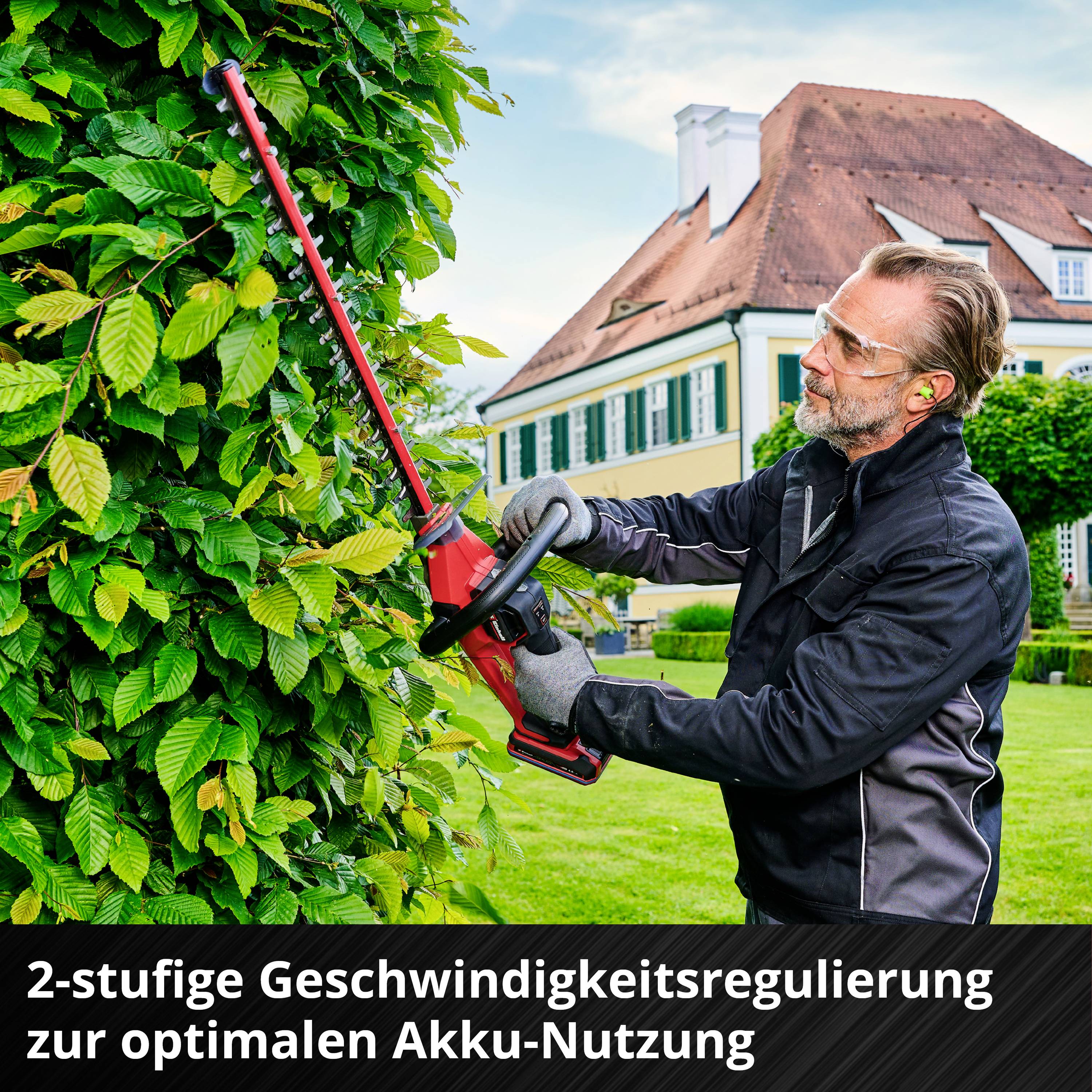 A man is using a battery-powered hedge trimmer in front of a house to trim the hedge. Text: 2-stage speed control for optimal battery usage.