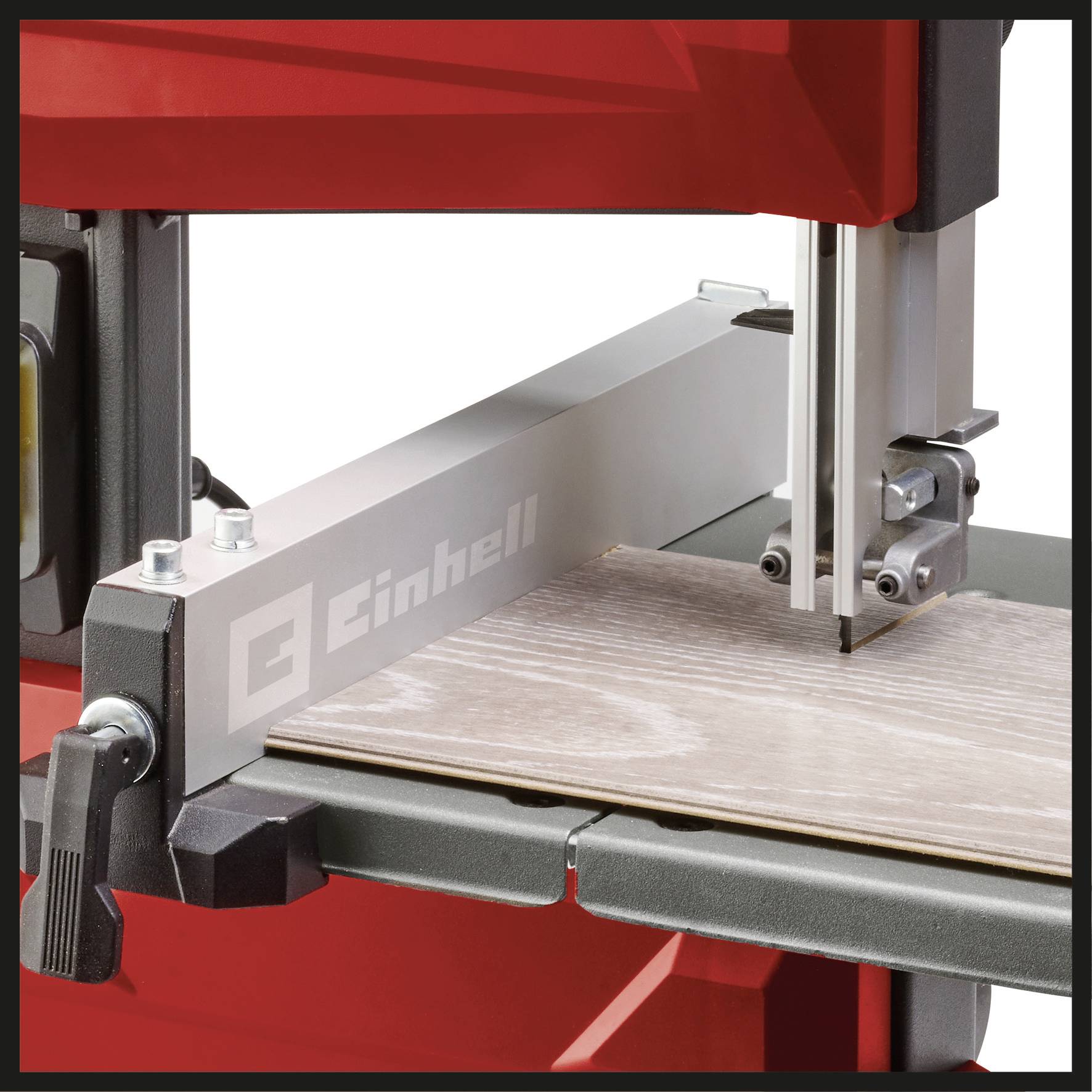 A bandsaw cuts precisely through a wooden board. The machine is partially red and has the 'Einhell' logo.