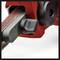 A belt sander with a red casing, black handle and grey sanding belt. Device used for surface finishing.