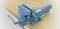 Blue vice, firmly mounted on a wooden workbench, open and ready to secure objects during processing.