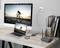 A computer monitor displays a cyclist at sunset. A laptop, connected to a router, shows the same image.