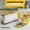 A white two-slice toaster. Beside it a glass of orange juice and a breakfast table with spread and bread rolls.