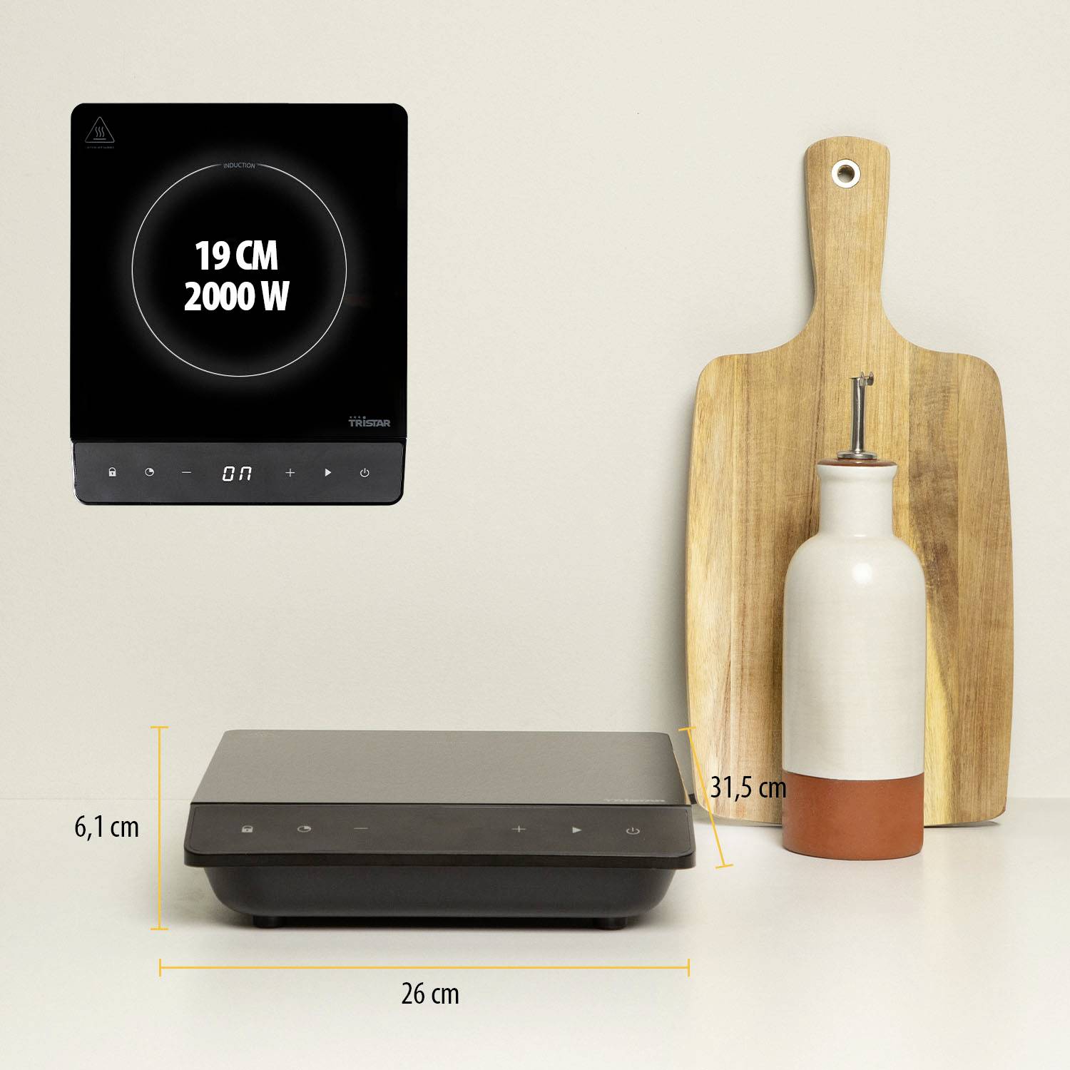 Compact portable induction hob with digital display on a table; Dimensions: 6.1 cm high, 26 cm wide; Power: 2000 W.