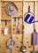 Garden tools and accessories on wooden wall: straw sunhat, blue watering can, garden spade, rake, seedlings, hosepipe, and hanging plant.