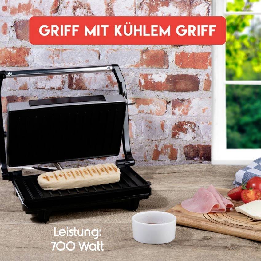 Grill with bread on table in front of brick wall. Text at top: 'Handle with cool grip'. Bottom: 'Performance: 700 Watts'.