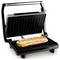 A panini press with a sandwich filled with cheese and ham. The grill has ribbed black plates.