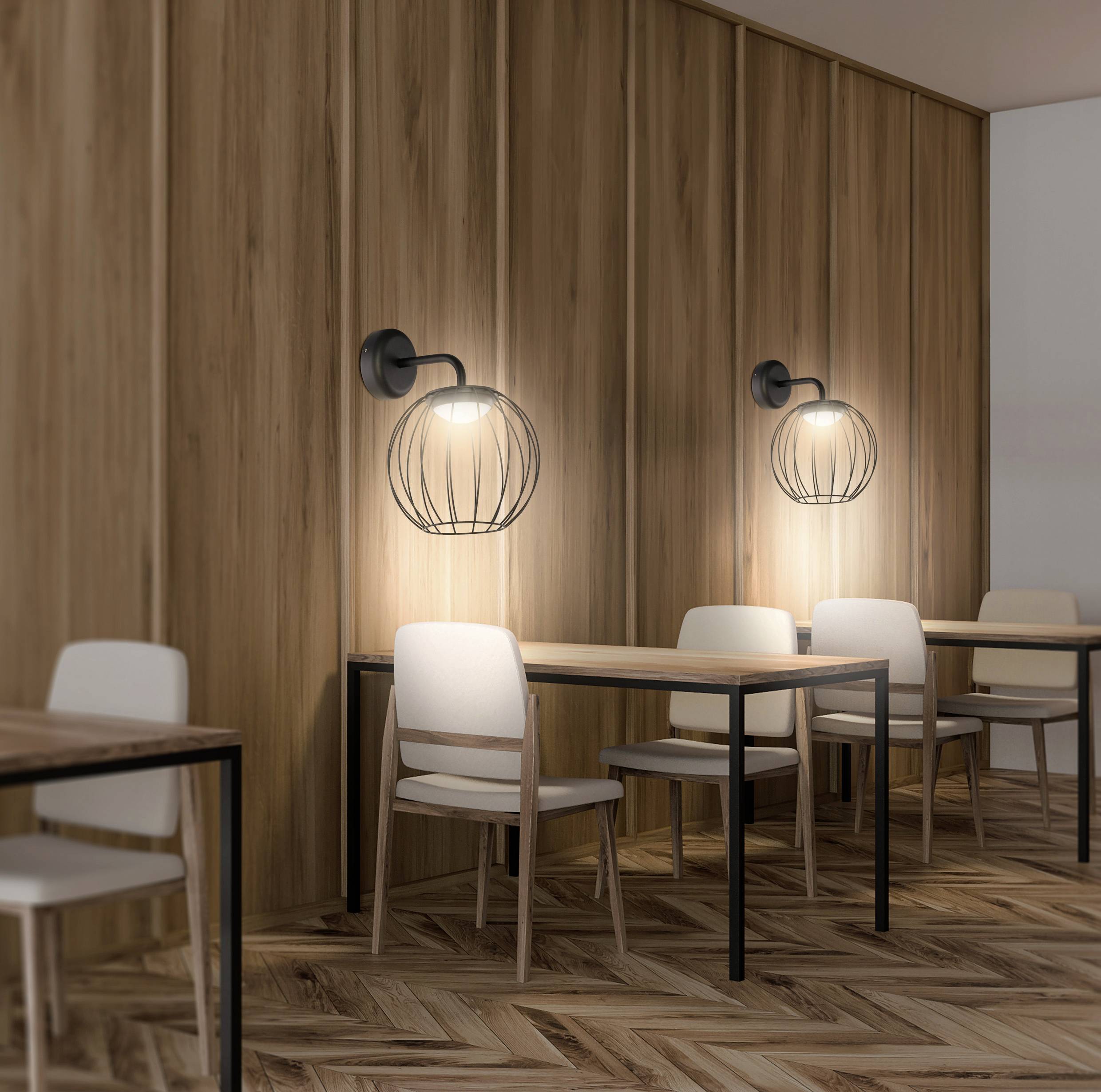 A modern cafe interior with wooden walls, warm lighting, and simple furniture, featuring small tables and chairs along the wall.
