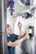 A man is using a measuring device to check heating pipes in a boiler room. He is holding a sensor against the pipe.