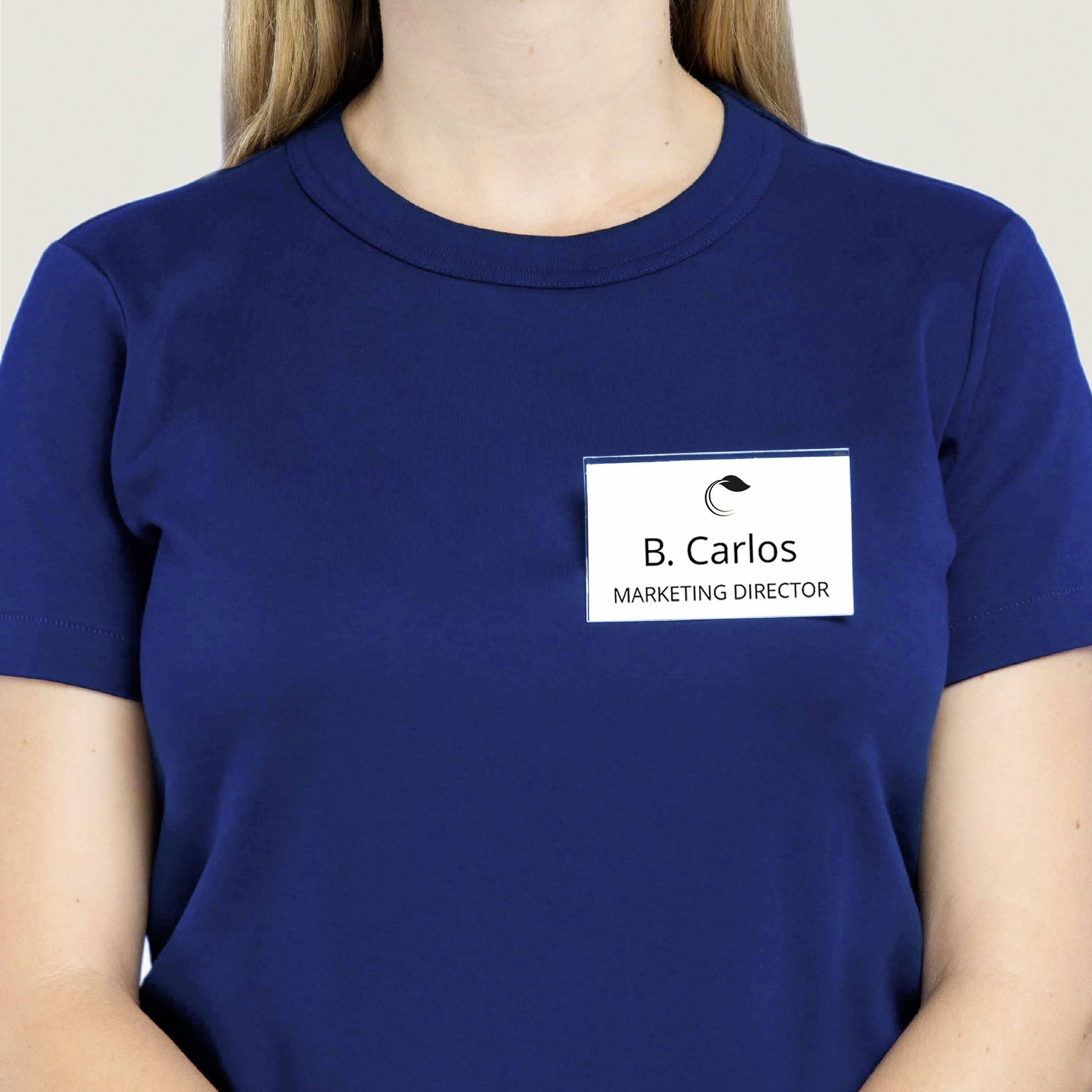 A person is wearing a blue T-shirt with a name badge reading 'B. Carlos, Marketing Director'. Their face is not visible.