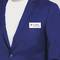 A person in a blue suit is wearing a name badge that reads 'K. Jones, Receptionist'.