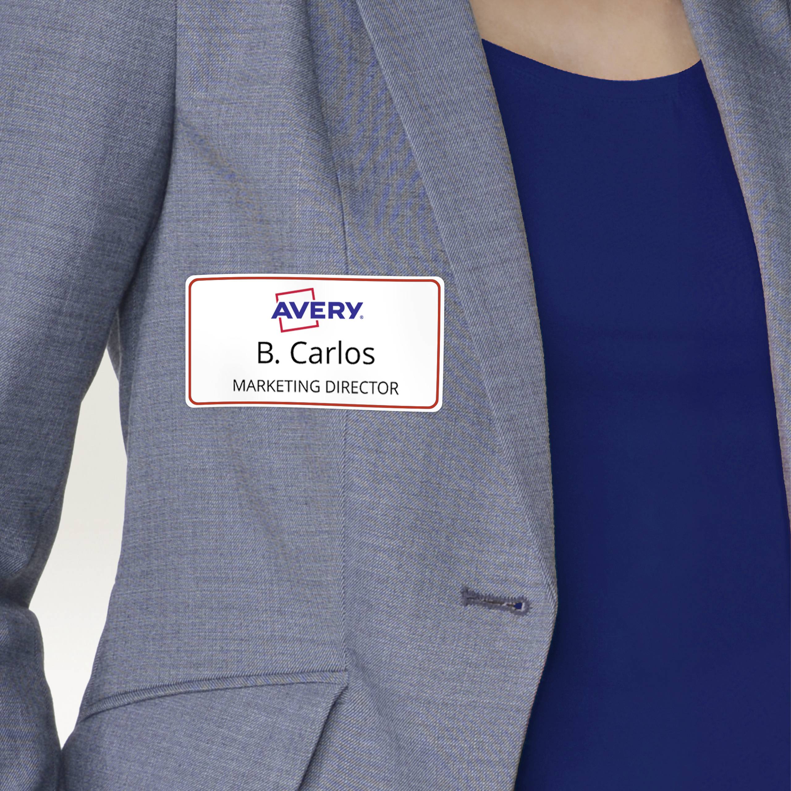 A person is wearing a name badge on a grey blazer with the inscription 'B. Carlos, Marketing Director'.