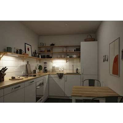 Small, modern kitchen with white cupboards, wooden worktops, wall shelves and a small wooden table with two chairs. Atmospherically lit.
