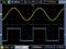 'Oscilloscope display showing a yellow sine wave and a blue square wave. Yellow wave: 2.0V. Blue wave: 2.0V.'