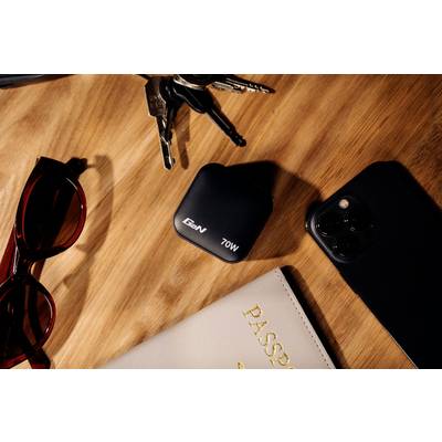 'A desk with sunglasses, keys, a 70W charger, a smartphone and a passport with the inscription 'PASSPORT'.'
