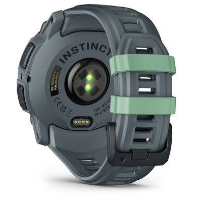 Back of a robust, grey digital wristwatch with a green accent on the strap, optical sensors and 'INSTINCT' marking.