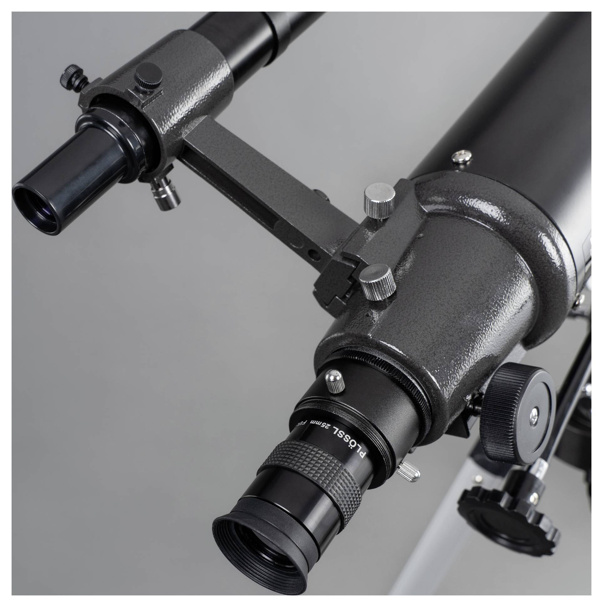 A telescope with a black casing and focusing wheels. View of the eyepiece, suitable for stargazing or celestial research.