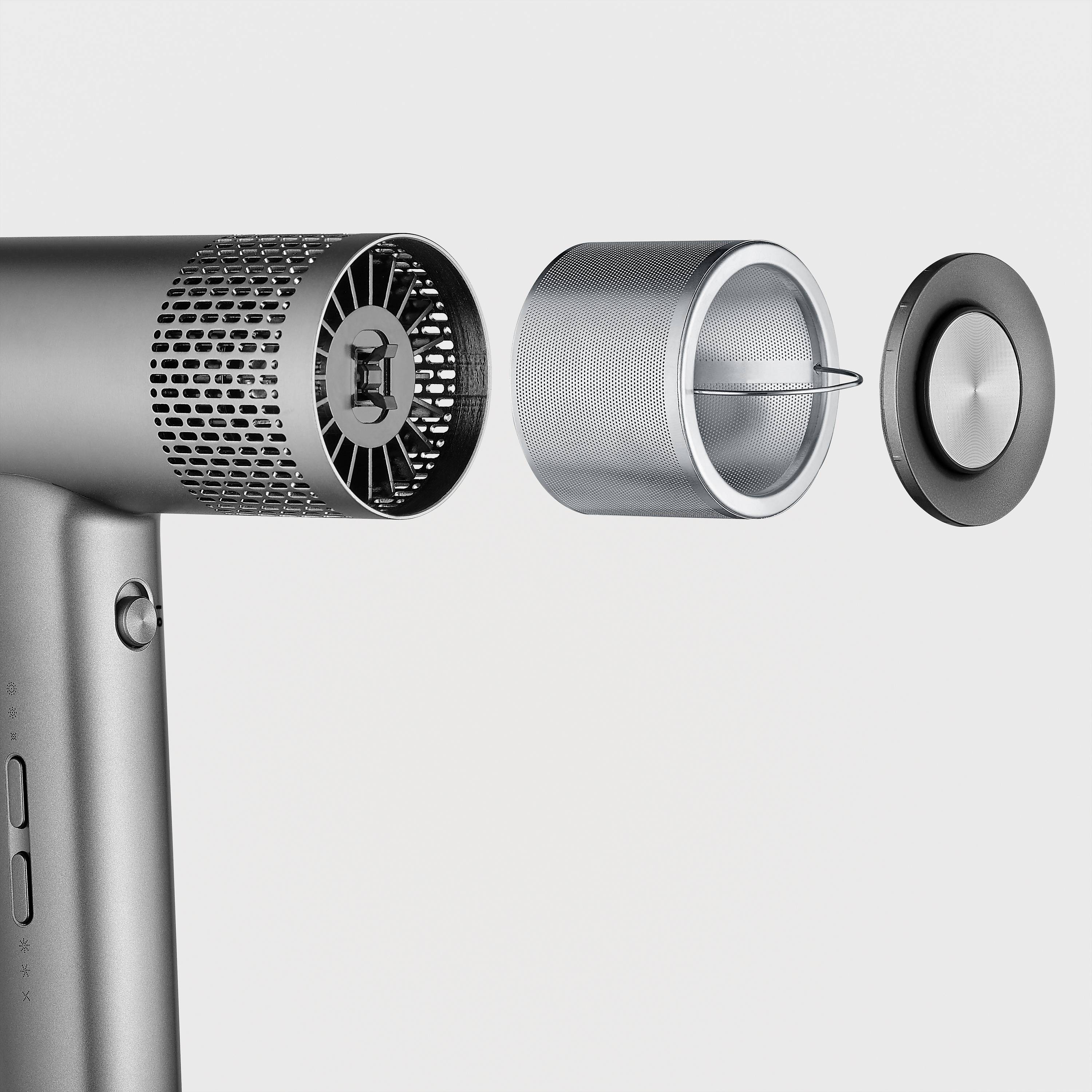 Grey hairdryer casing with the rear filter cap removed, revealing a three-part filter insert, set against a white background.