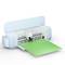 A light blue electronic cutting device with a green cutting mat insert. Perfect for precise crafting and handiwork.
