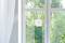 An automatic window cleaning robot is attached to a large glass pane. Outside, trees and green foliage are visible.