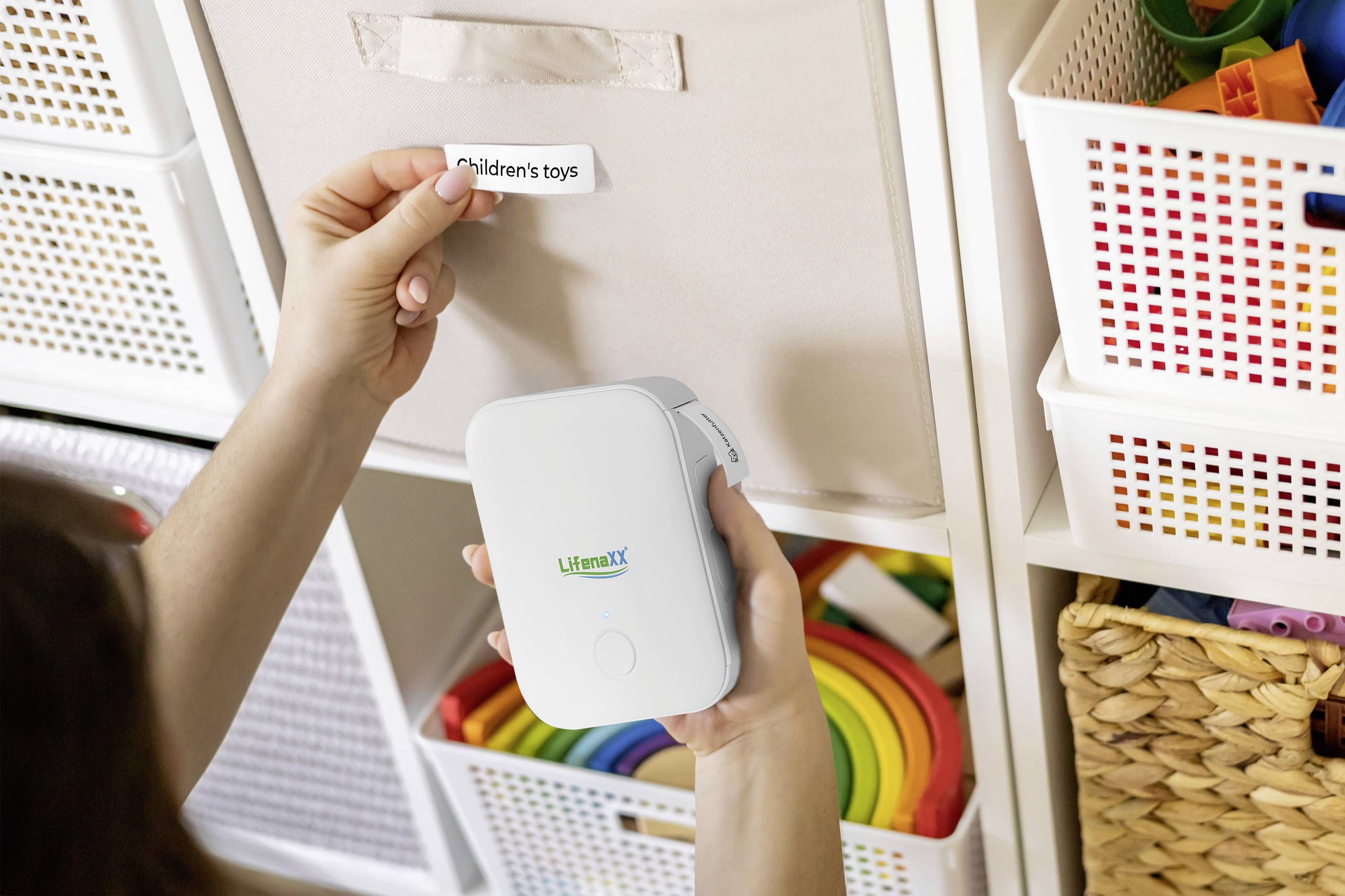 A person is attaching a label reading 'Children's toys' to a box. The box contains colourful toys.