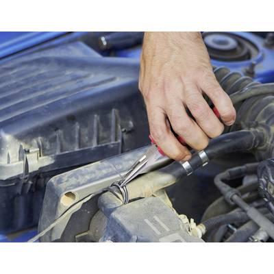 A hand uses pliers to twist wires under a car hood, performing maintenance or repairs on the vehicle's engine components.