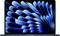 A laptop screen displays a blue-black, abstract wave pattern.