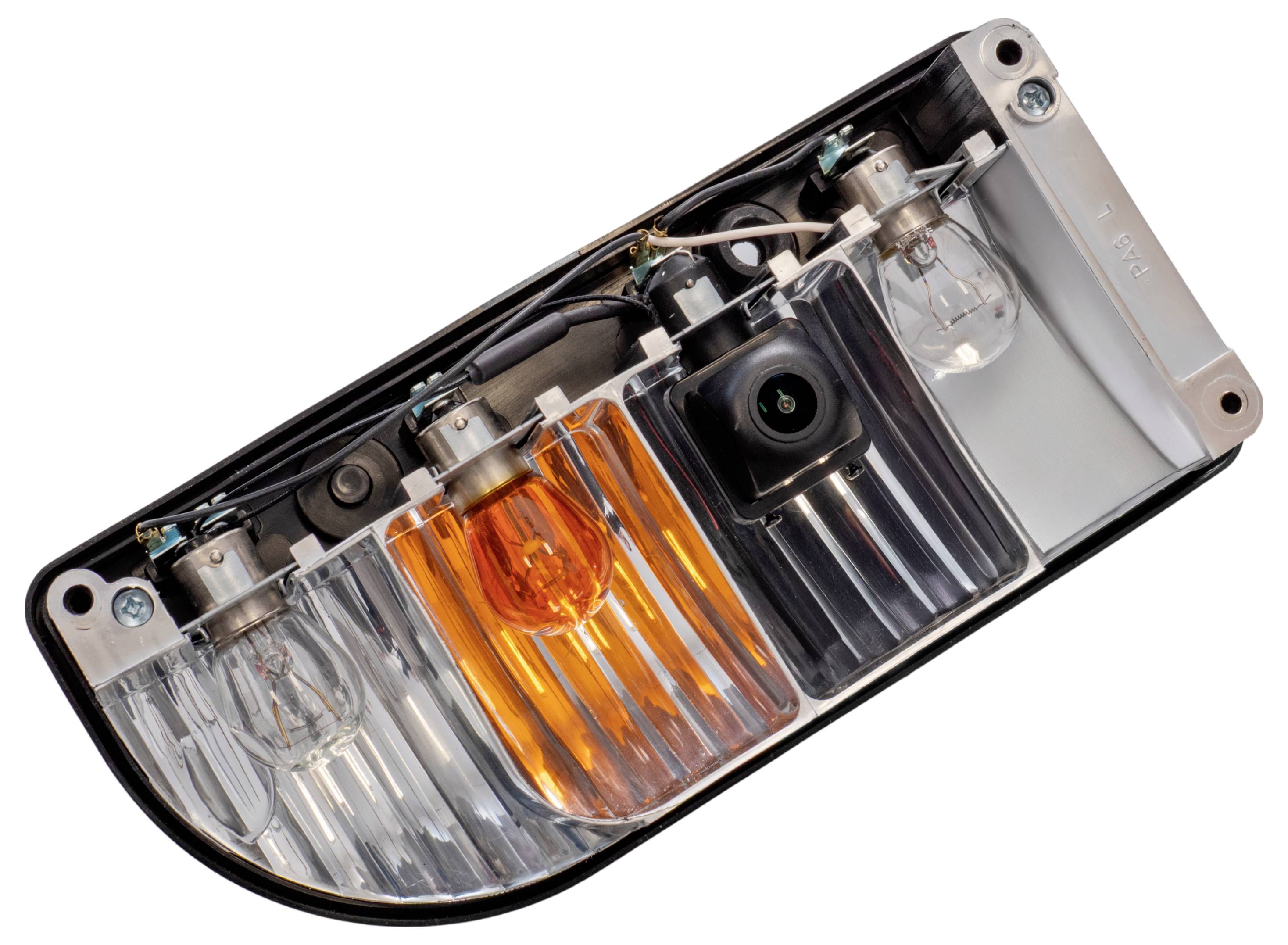 'A car tail light assembly is shown featuring two light bulbs, an orange indicator, a clear lens, and a rear-view camera attached.'