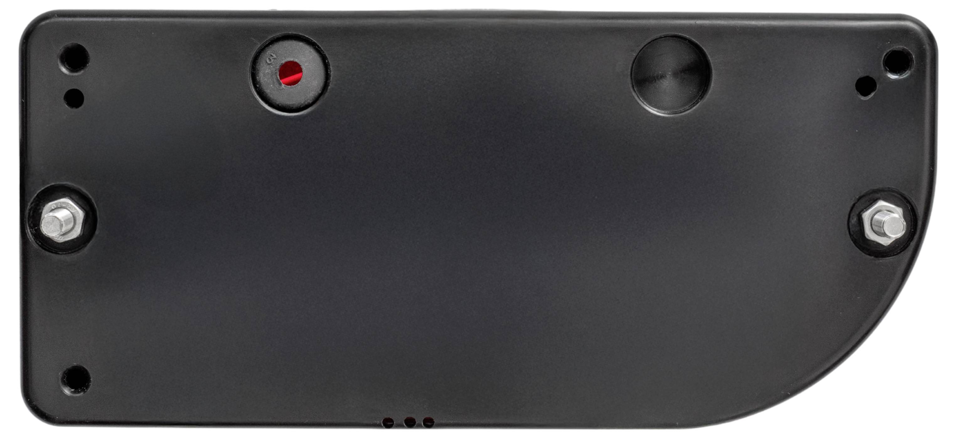 A close-up of a black rectangular device with visible screws and a red indicator. The device has various circular and semi-circular openings.