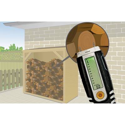 An outdoor wood store, filled with logs. A moisture metre shows a reading of 0.0, indicating the dryness of the wood.