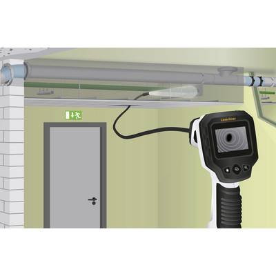 An infrared thermometer scans the area above a door in a building. An emergency exit sign is visible.