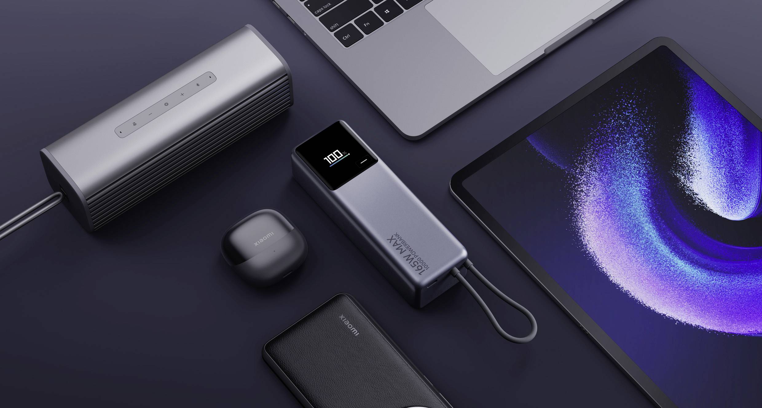 Several electronic devices, including a laptop, a tablet, wireless headphones and a speaker, are connected to a portable charger.