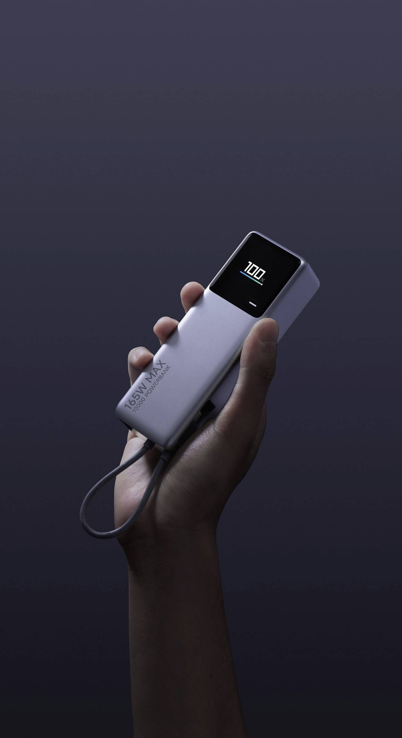 A hand is holding a portable device with a small screen displaying '100'. The device has a minimalist design.