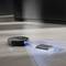 A robotic vacuum cleaner scans a book on the floor. The robot uses laser technology to detect and navigate around obstacles.