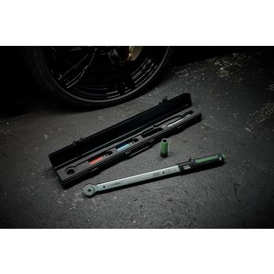 Torque wrench and sockets on concrete floor beside tyre. Tool protective case open in the background.